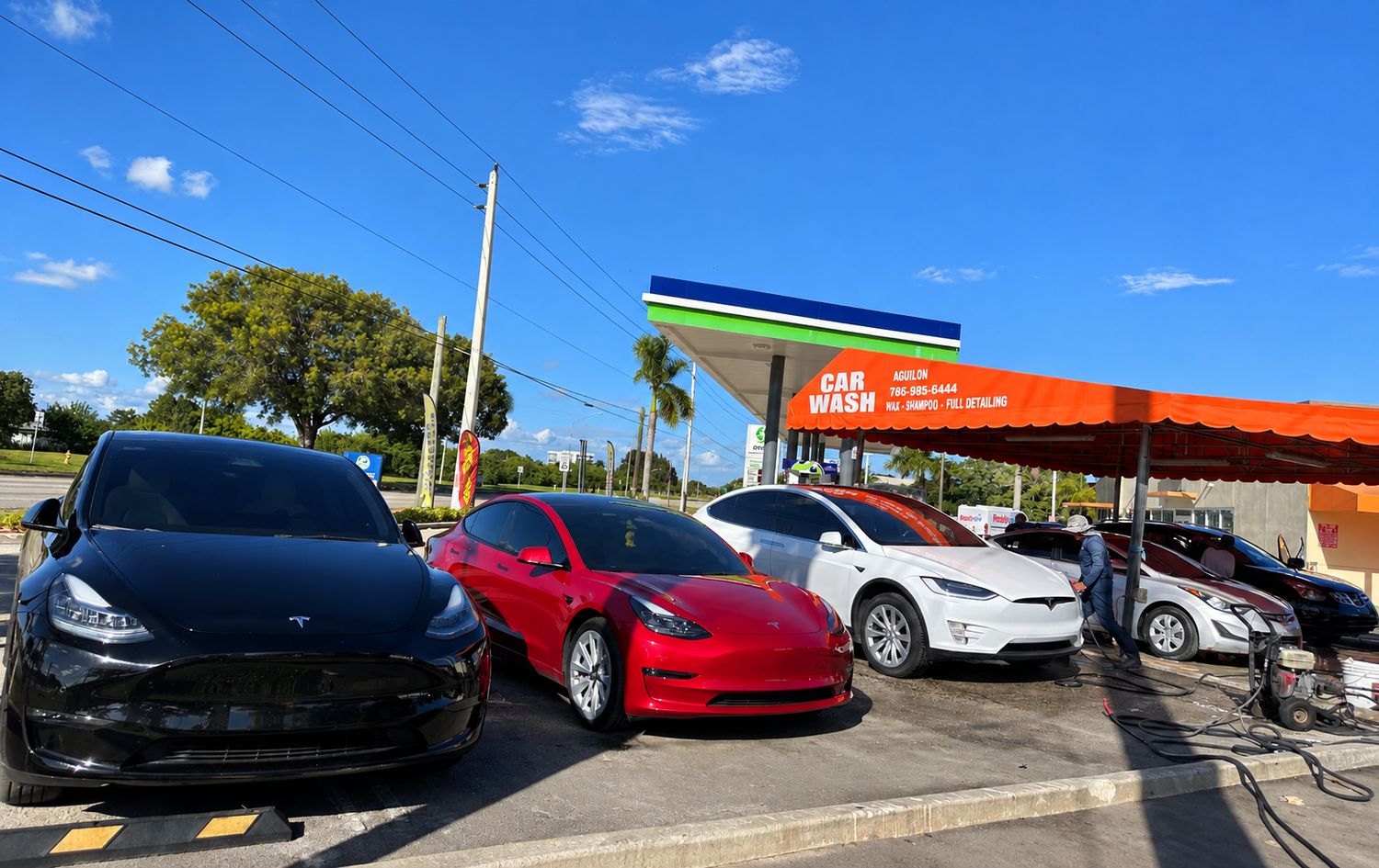 Tesla Model Y, Model 3 and Model X lined up for a hand wash under the Car Wash Aguilon canopy